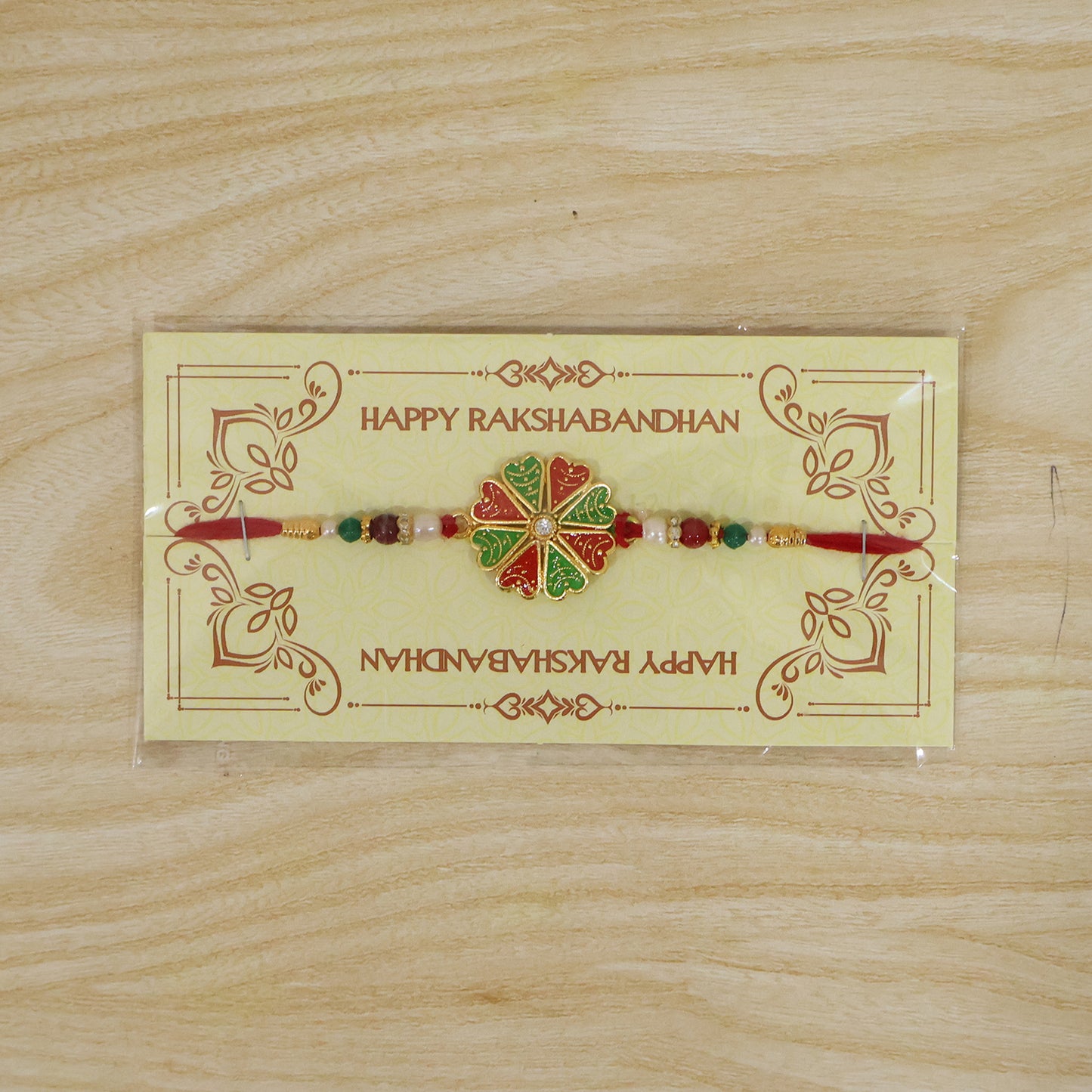 Angled view of the traditional rakhi showcasing its crystal and pearl details.