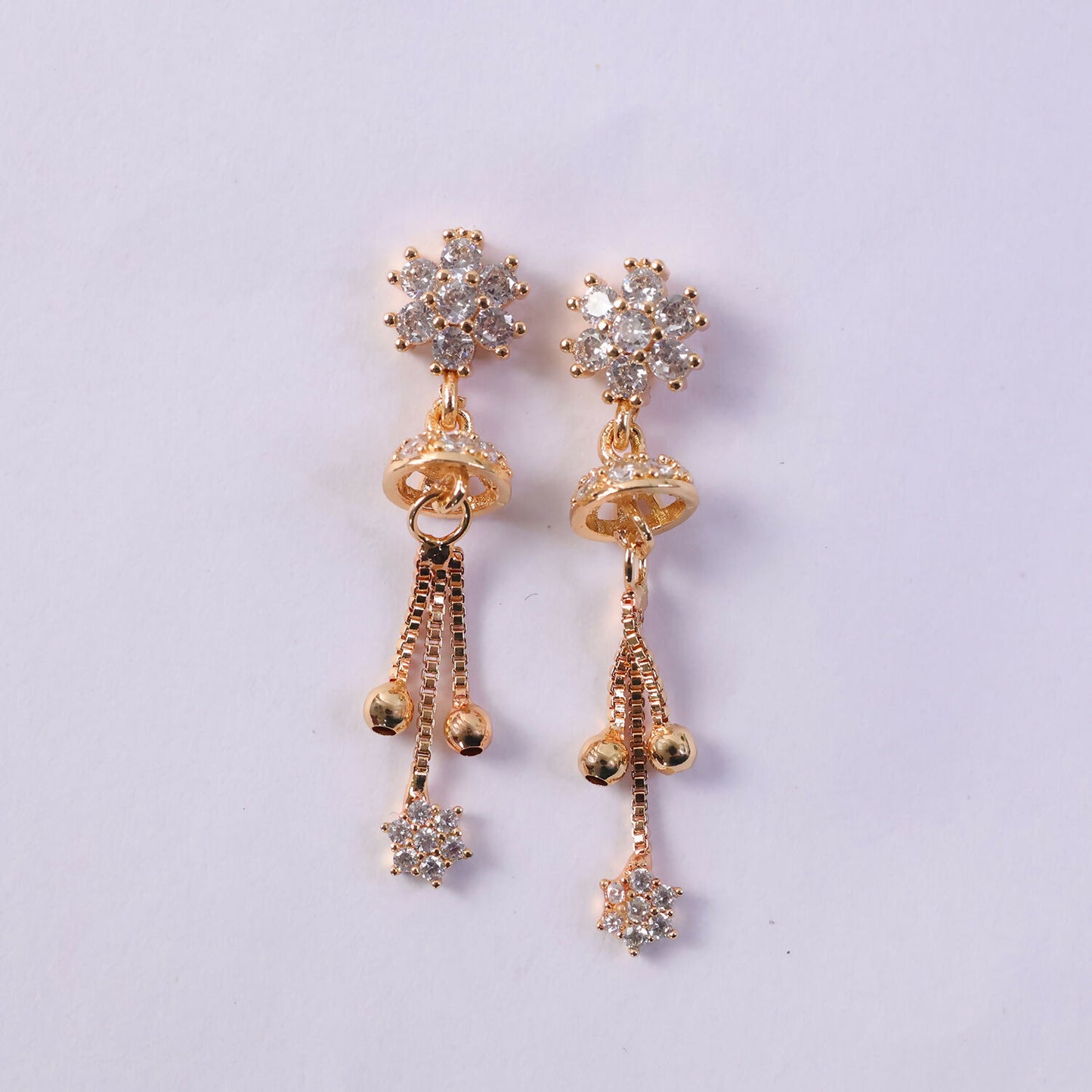 Detailed image of floral crystal drop earrings highlighting floral sparkle and gold-tone chains