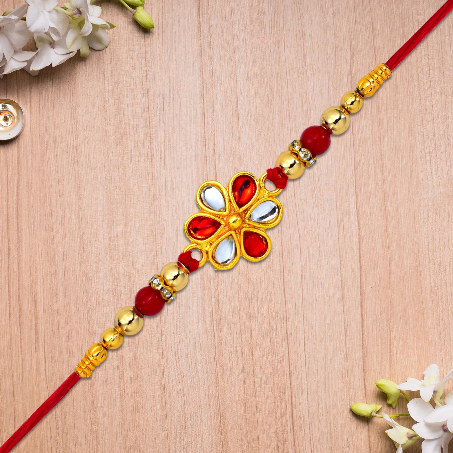 Elegant red and white beaded rakhi with teardrop kundan floral centerpiece