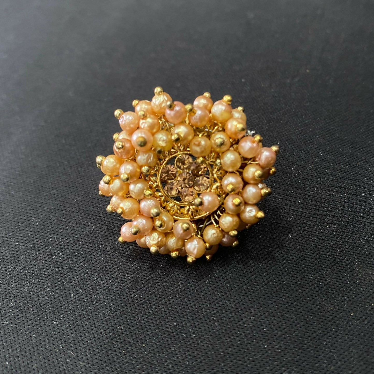 A woman's hand modelling the beautiful gold plated pearl floral ring, perfect for occasions.