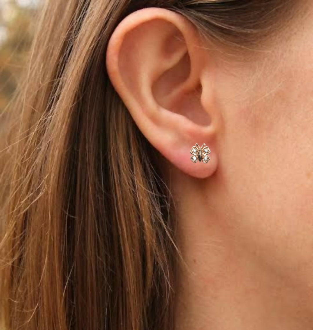 Rose gold plating on butterfly stud earrings shining under light