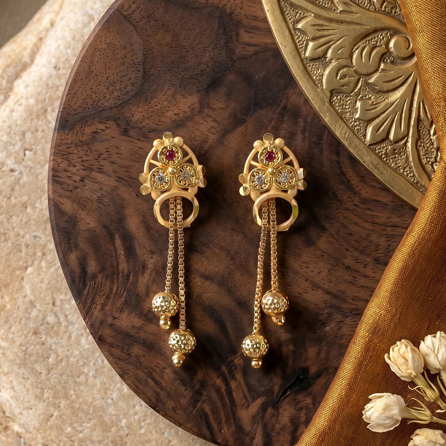 Close-up of leaf-inspired stud with ruby-red stone