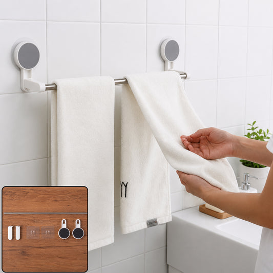 A person hangs a white towel on a silver self-adhesive towel rod in a white tiled bathroom.