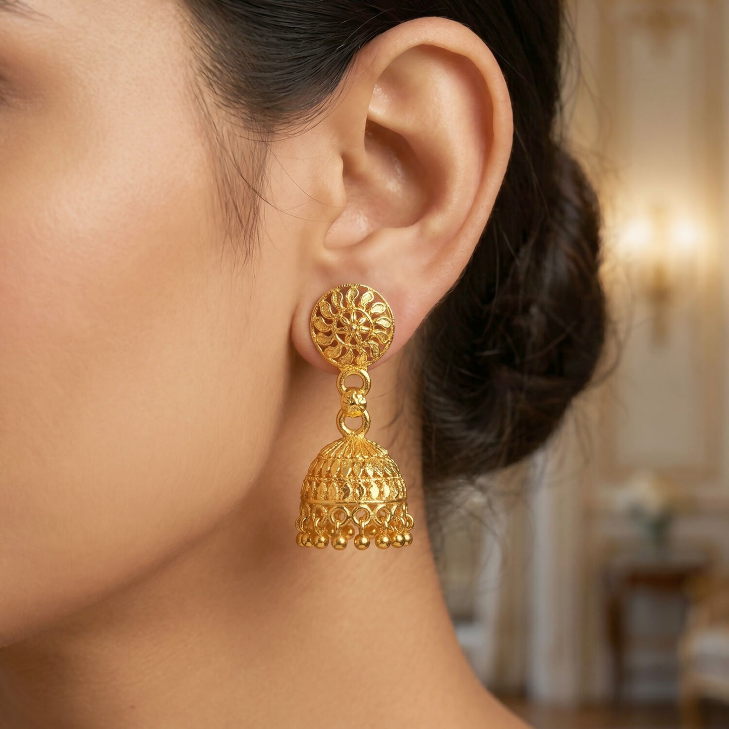 Close-up of gold jhumka earrings highlighting pearl accents