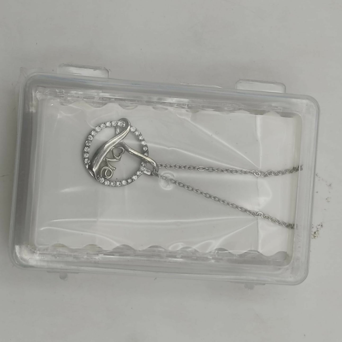 Model wearing the love script silver plated circle pendant necklace with adjustable chain