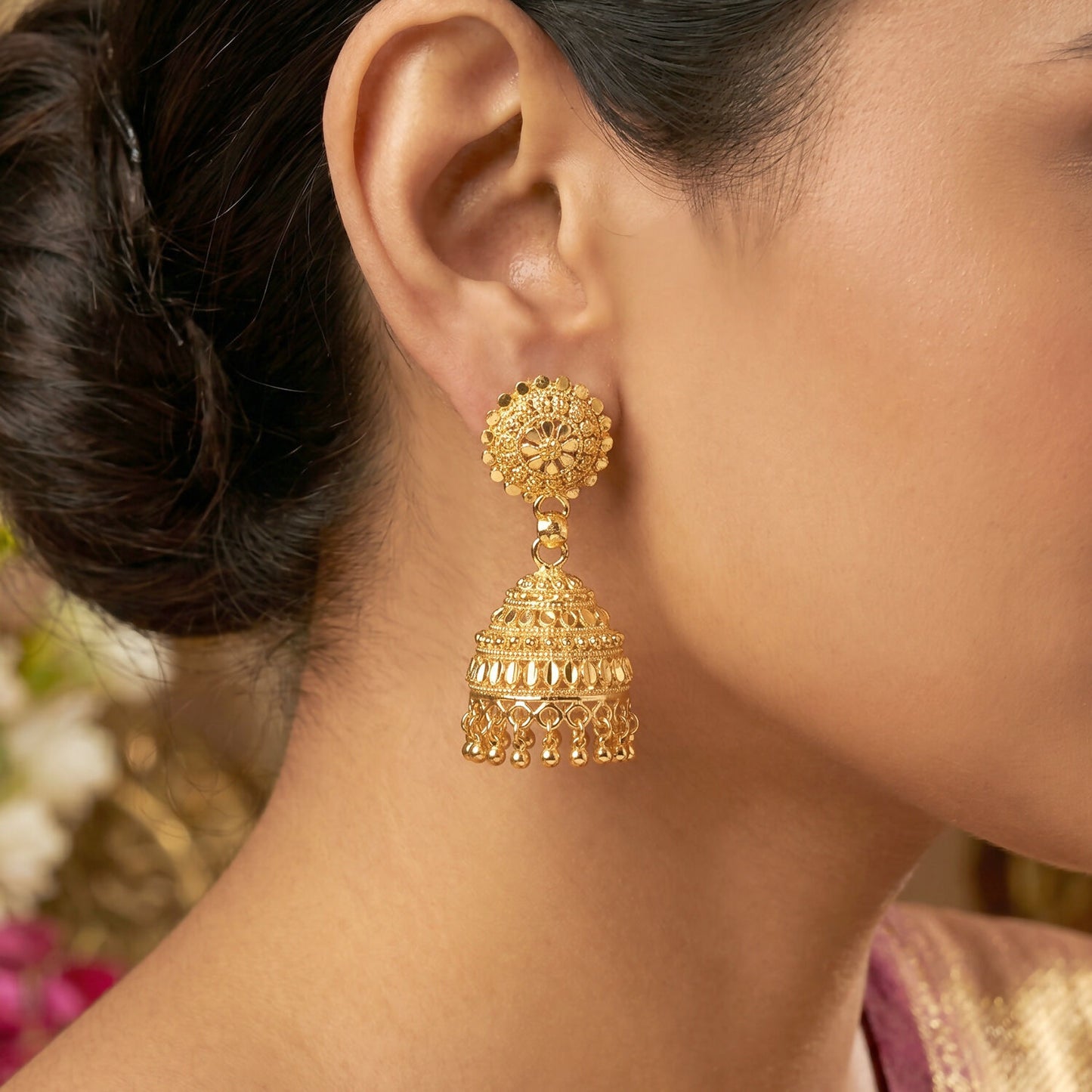 Close-up of pearl danglers on gold jhumka earrings