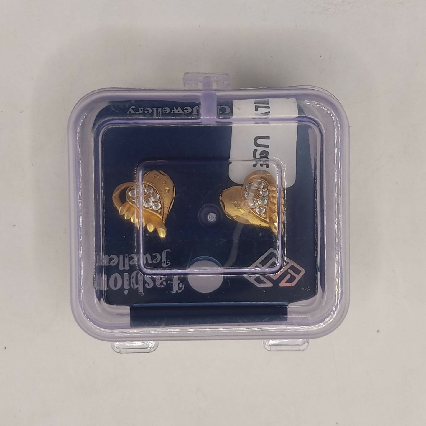 Pair of gold heart stud earrings displayed to showcase textured design and shimmer of crystals