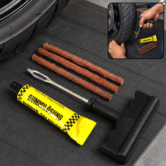A tubeless tire repair kit with a rubber solution tube, three brown repair strips, and a T-handle tool on a black mat next