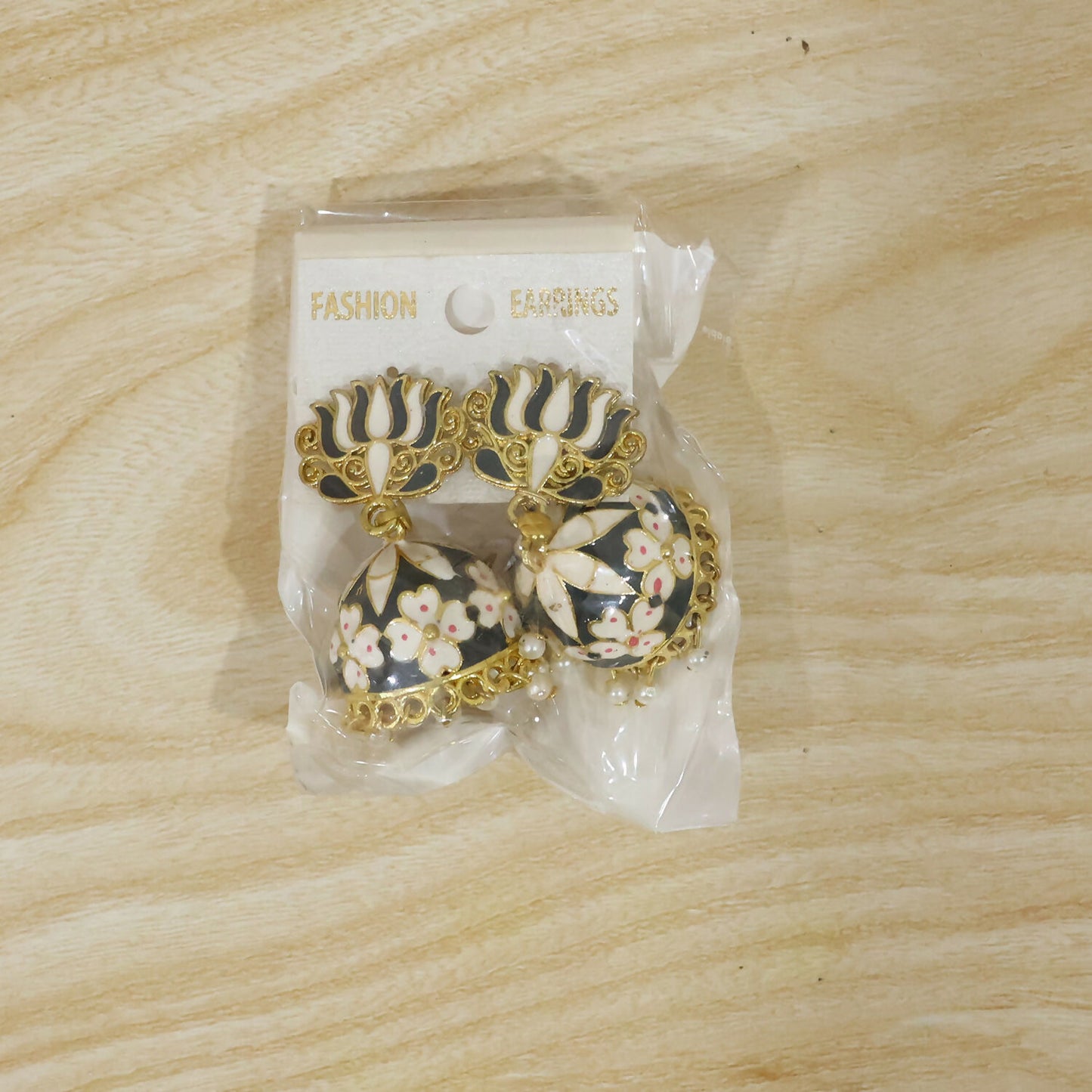 Grey lotus jhumka earrings showcased in natural light