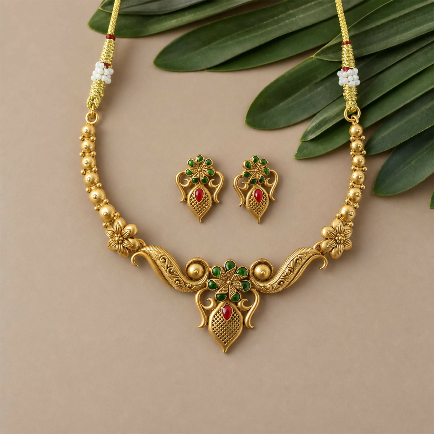 Detailed shot of one matching earring from the antique necklace set, featuring floral motifs and stone work.