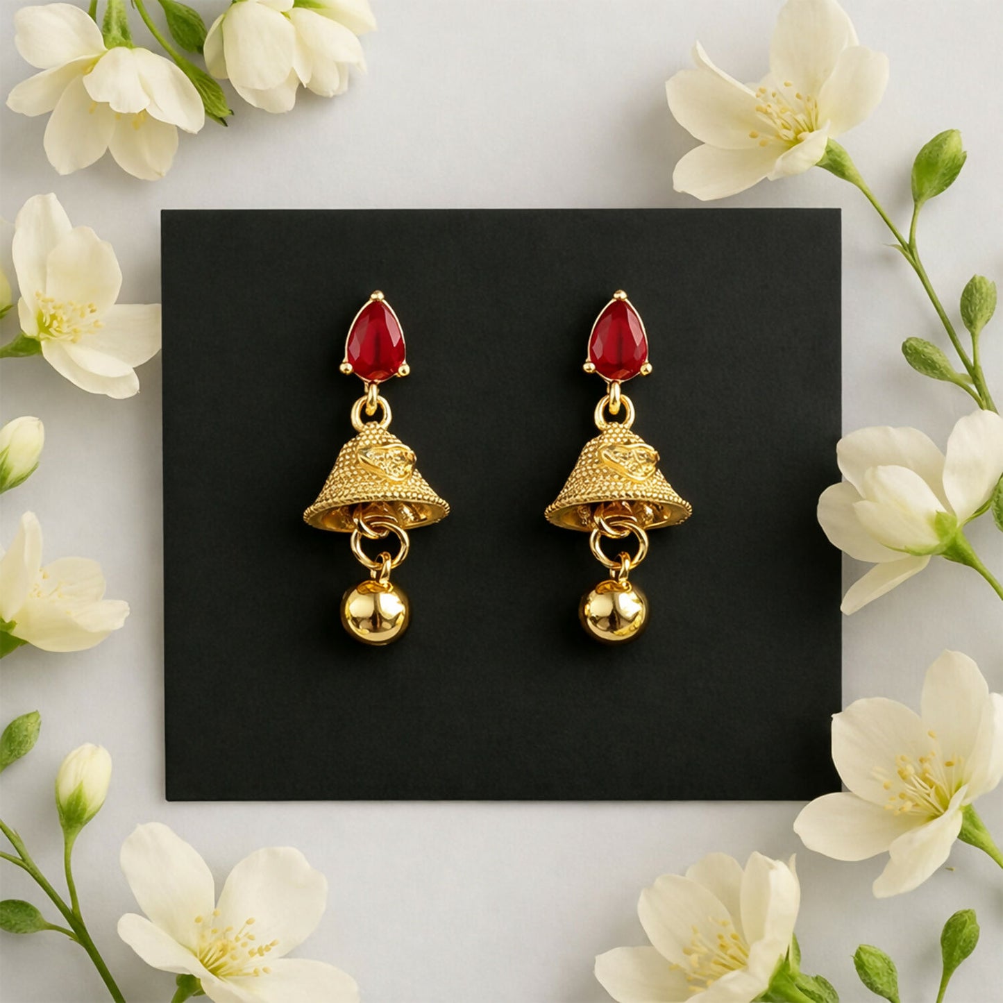 Close-up of ruby teardrop stone and intricate gold jhumka design