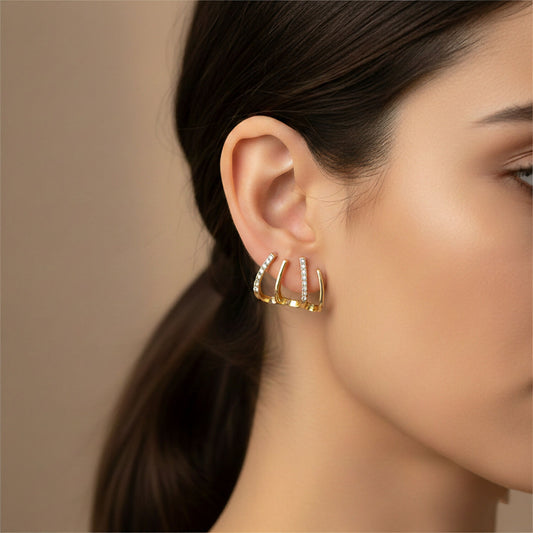 Model wearing gold multi-loop stone studded designer earrings