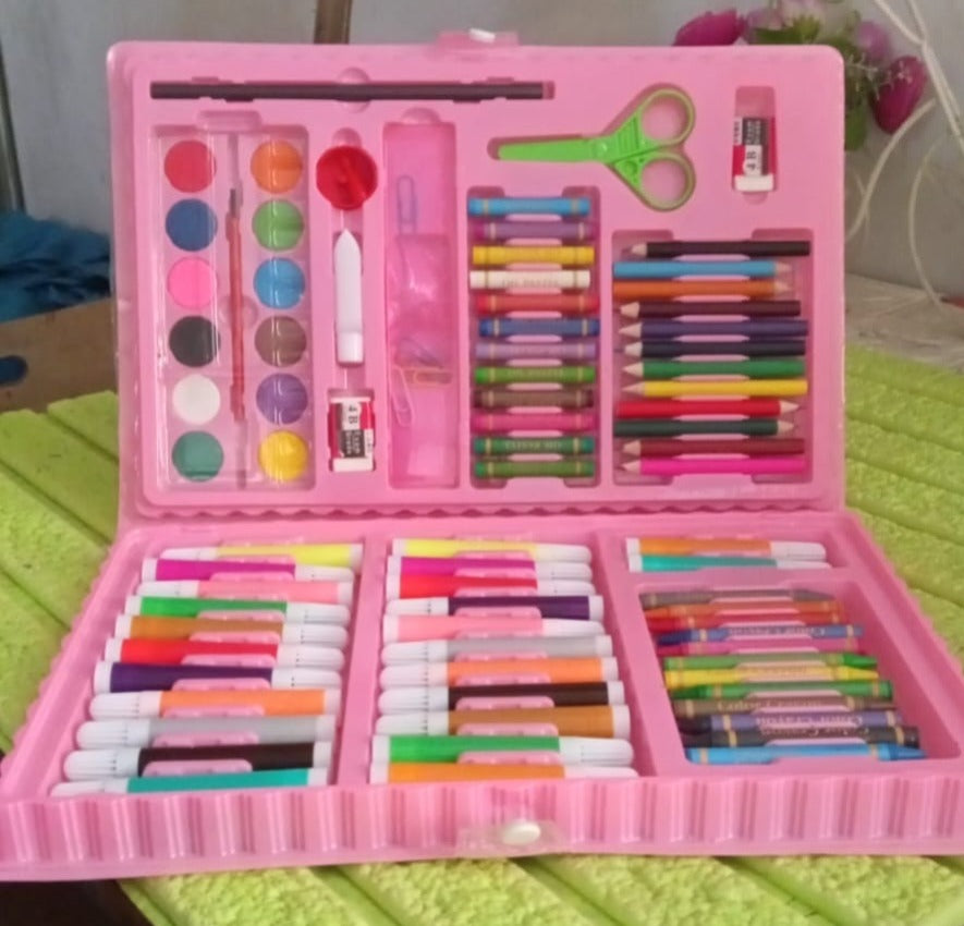 A pink art kit, brimming with diverse art supplies, rests on a textured light green surface.