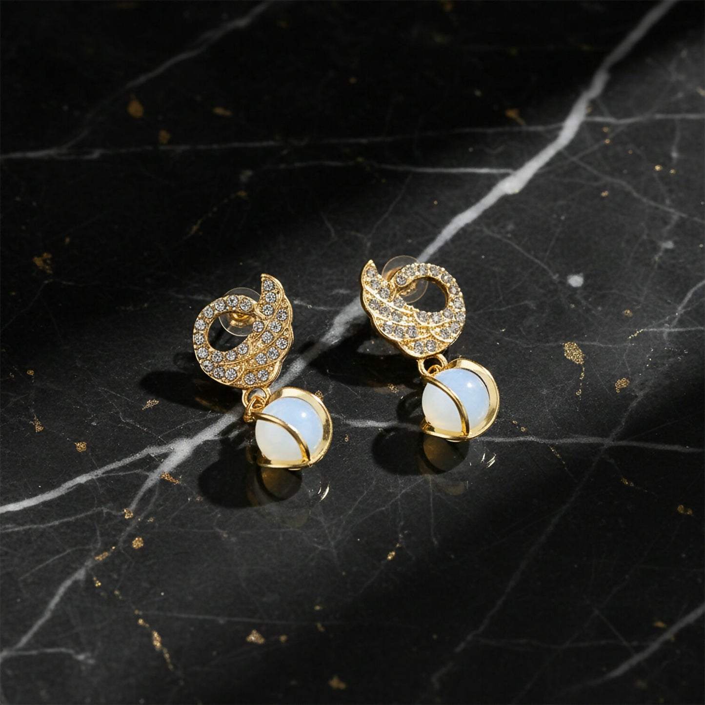 Swan earrings displayed on jewelry stand with light reflections