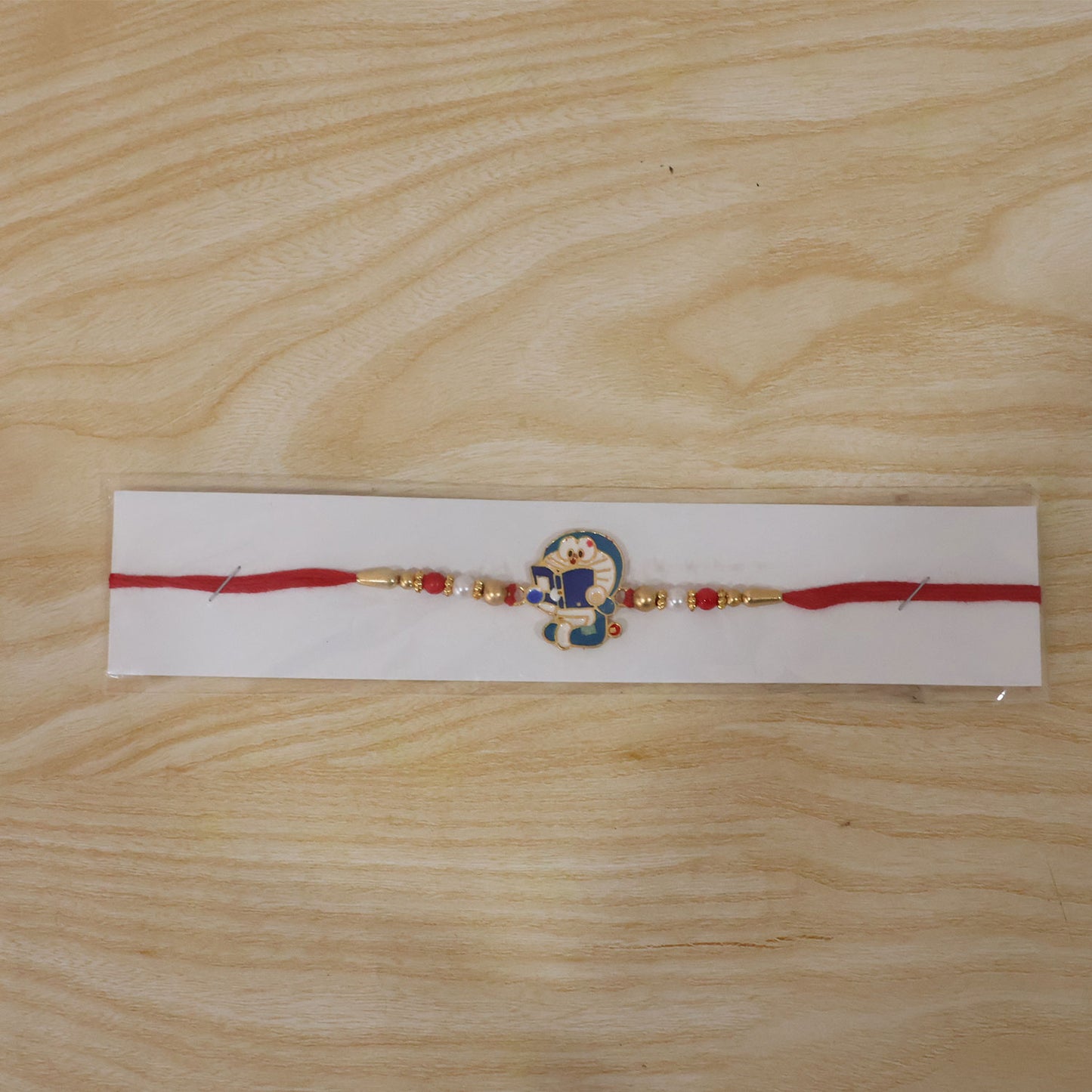 Doraemon Kids Rakhi with Red Gold Beads and Playful Blue Charm