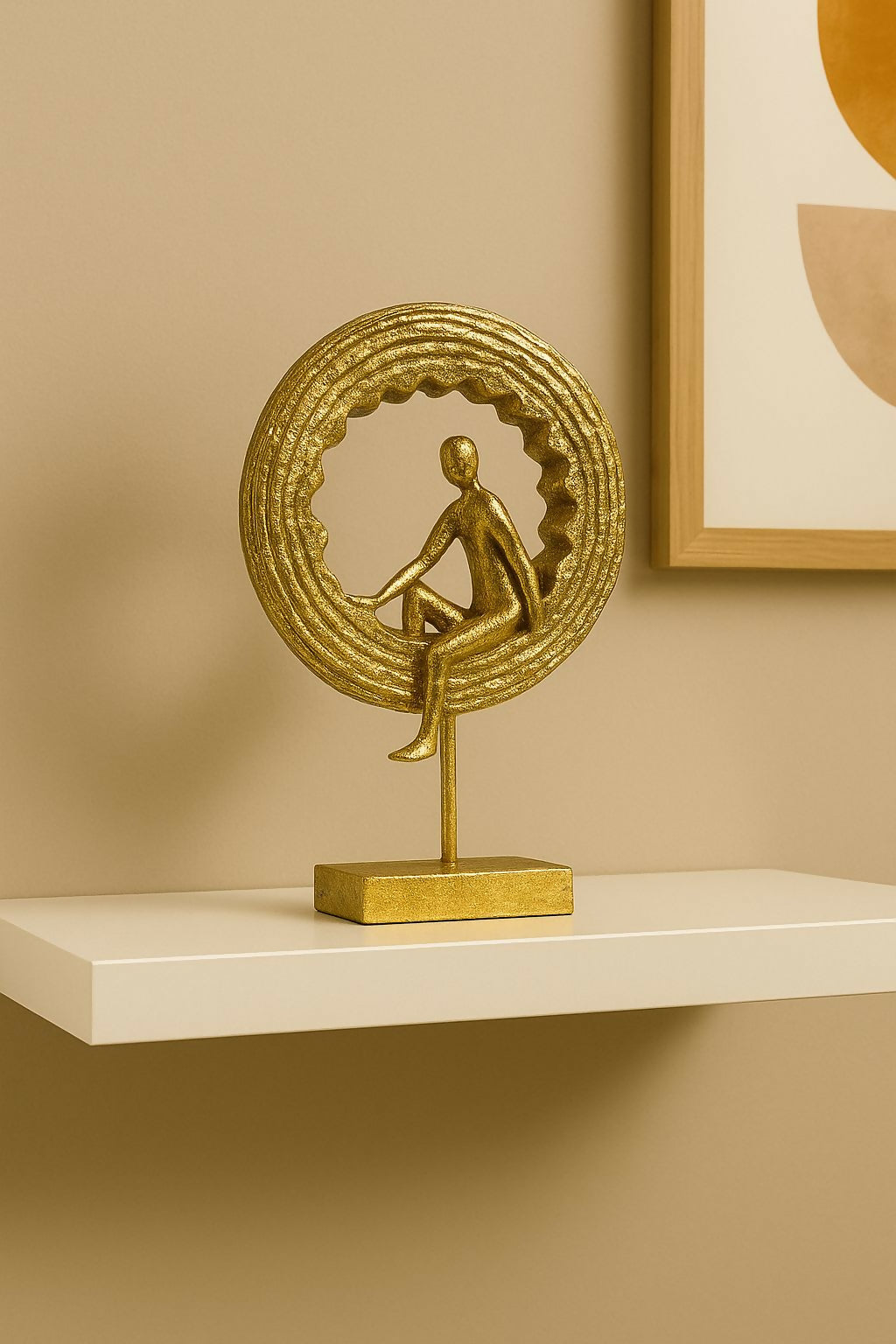 Golden yoga figurine statue displayed on shelf with ring backdrop