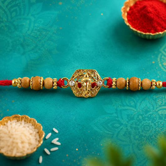 Close up view of Ganesh Devotional Rakhi with golden temple centre and wooden beads.