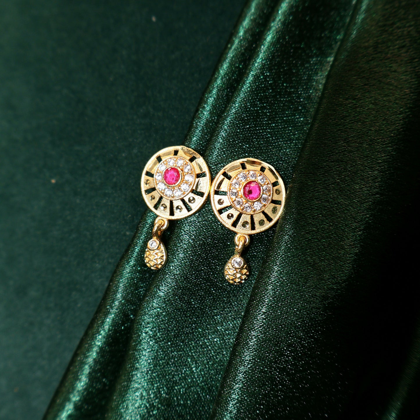 Close-up of gold plated pendant necklace with ruby stone and sparkling white stones