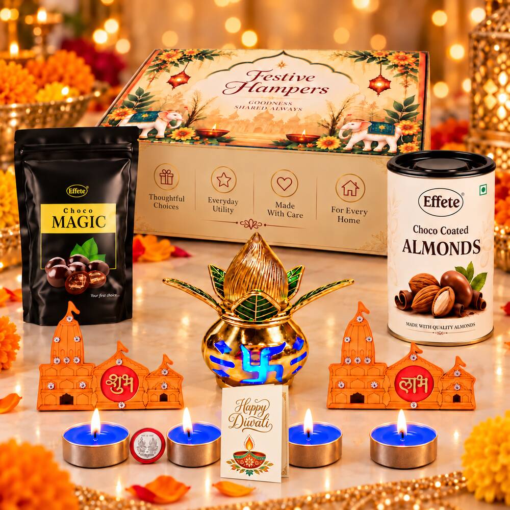 A Diwali gift set on a white marble surface with a gold kalash, wooden shubh-labh decor, and four lit blue tea lights.