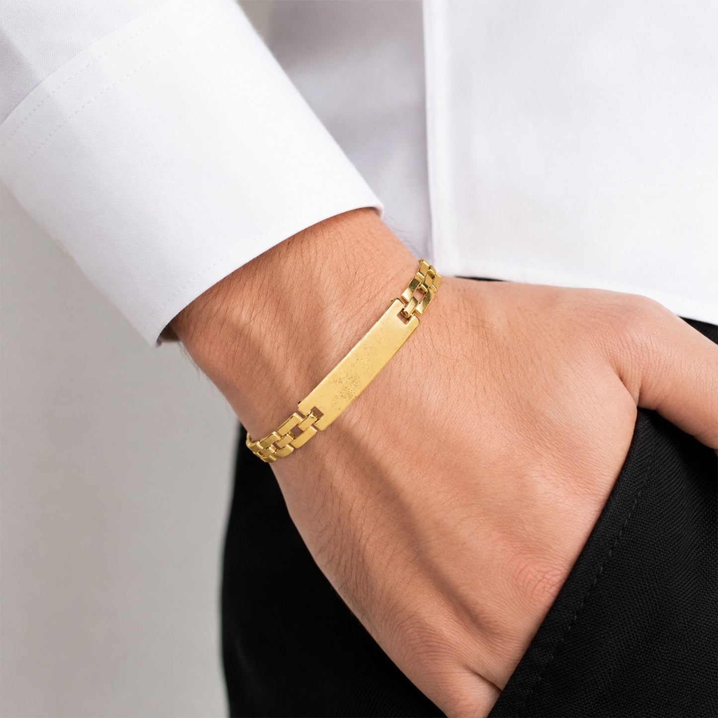 Personalized gold-plated bracelet displayed flat, highlighting the custom engraved nameplate.