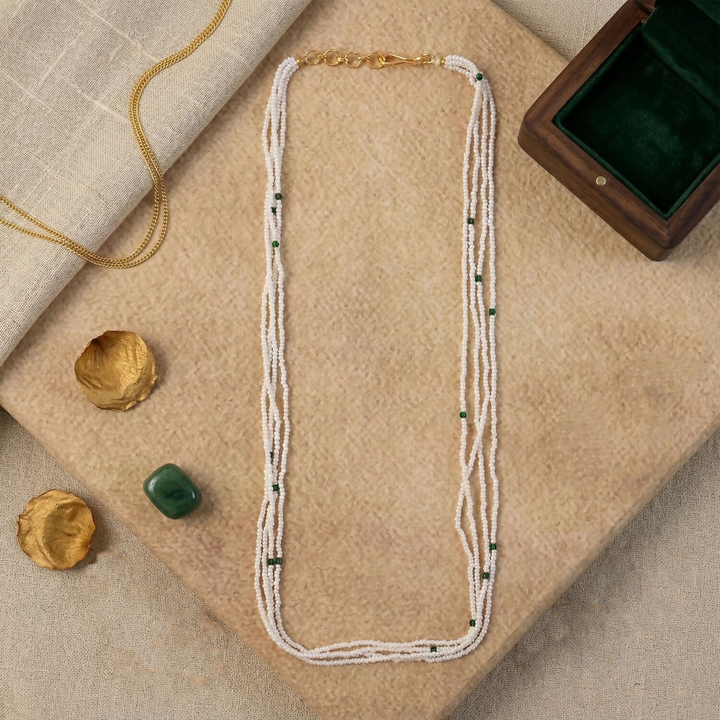 Woman wearing elegant white beaded mala with green accents
