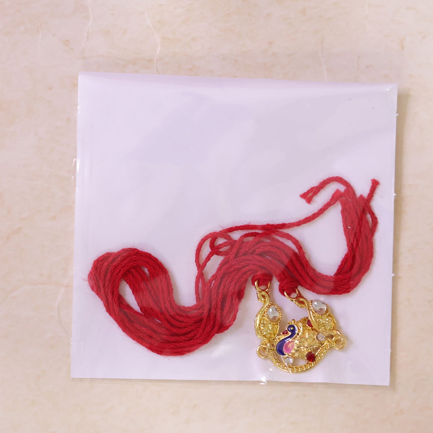 Elegant Rakhi showcasing Peacock Charm, color stones and gift style for Gift Styling