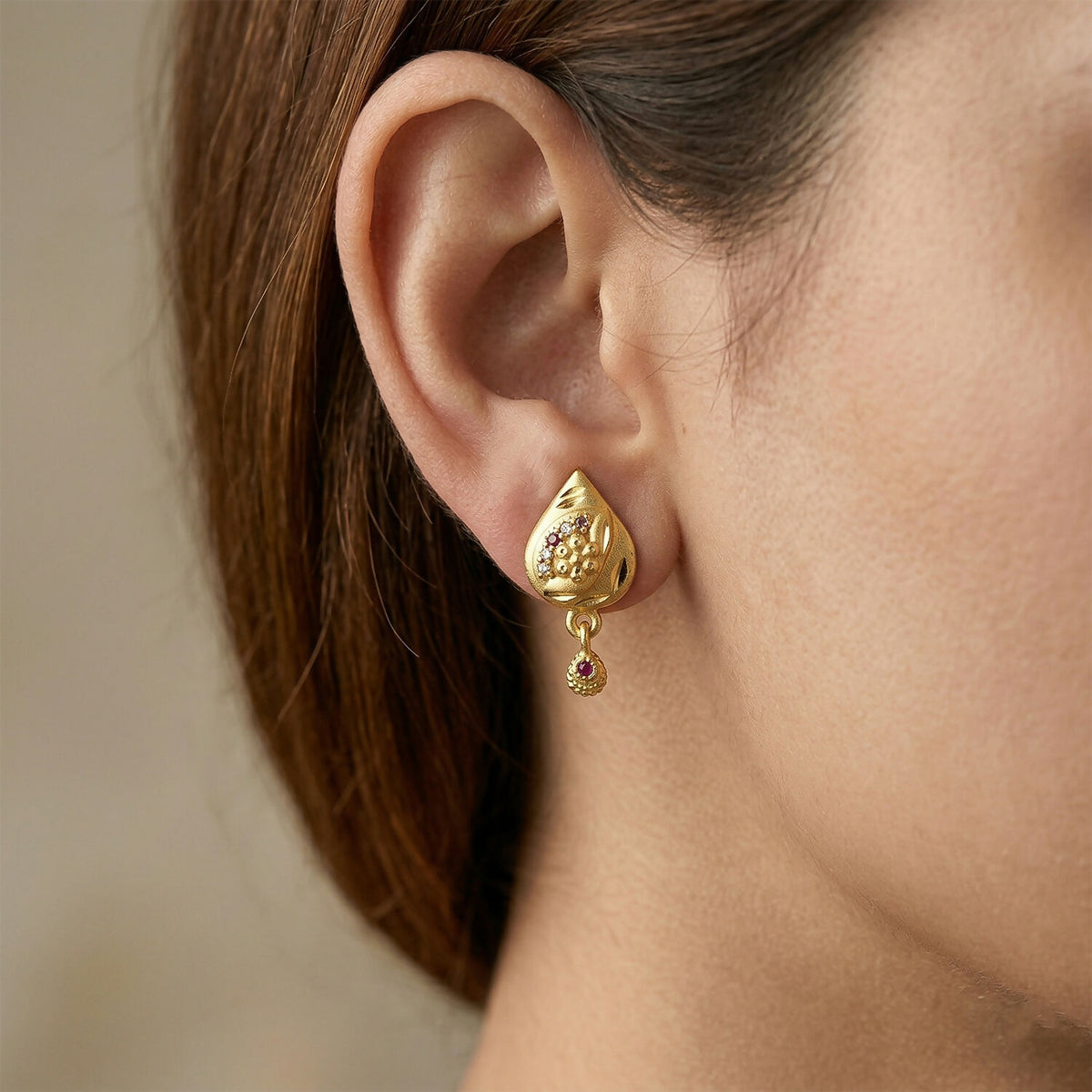 Close-up of gold plated geometric drop earrings with delicate design