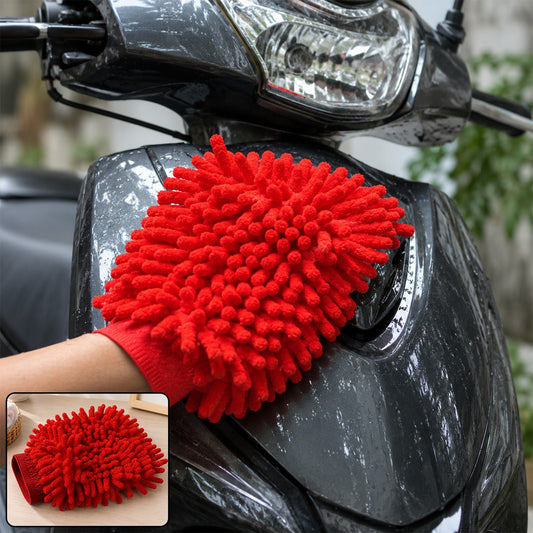 A person's hand in a red microfiber chenille wash glove cleaning the dark gray body of a scooter.