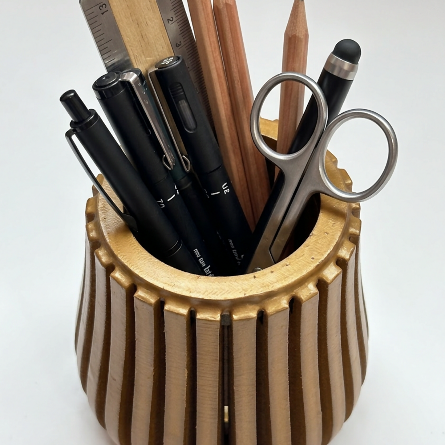 Modern wooden desk organizer stand holding various pens, pencils, and office supplies.
