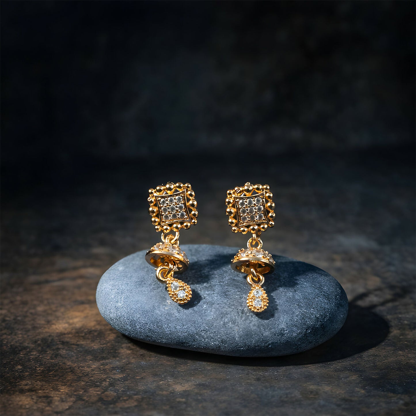 Side view of layered gold Jhumka drop earrings featuring teardrop charms
