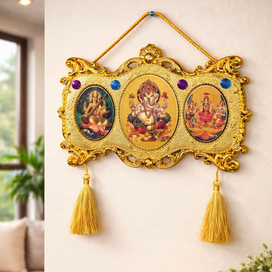 Close-up of gold-plated Ganesha Lakshmi Saraswati wall hanging with gemstone accents