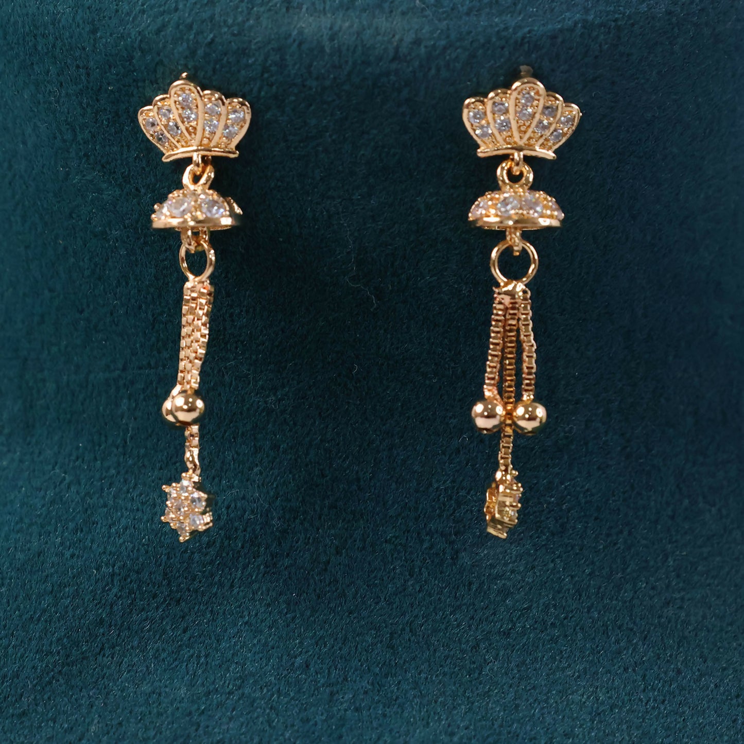Close-up side view of crown design gold finish drop earrings featuring sparkling crystal tassels