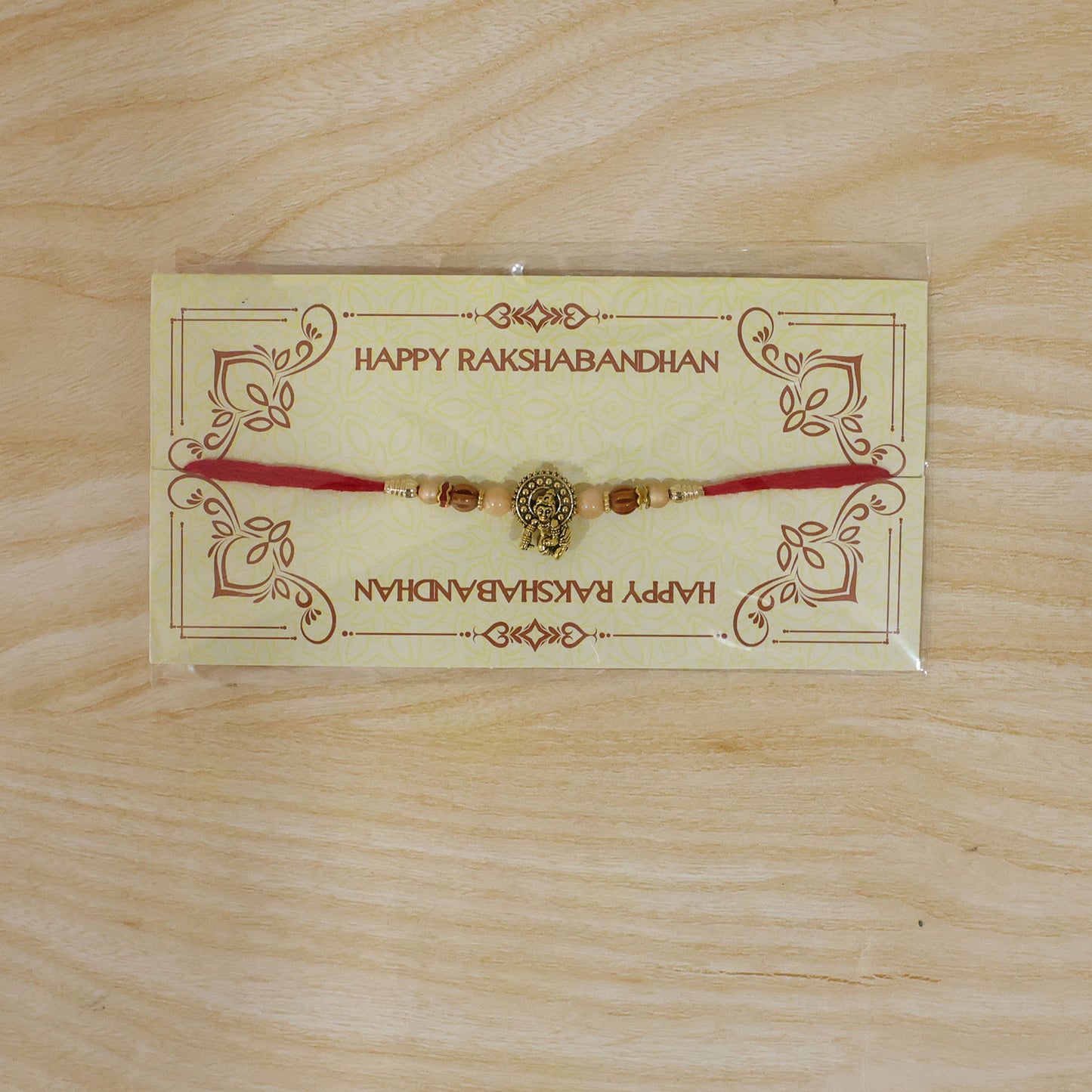 Antique Deity Idol Devotional Rakhi with Golden Medallion, Peach Beads and Red Thread