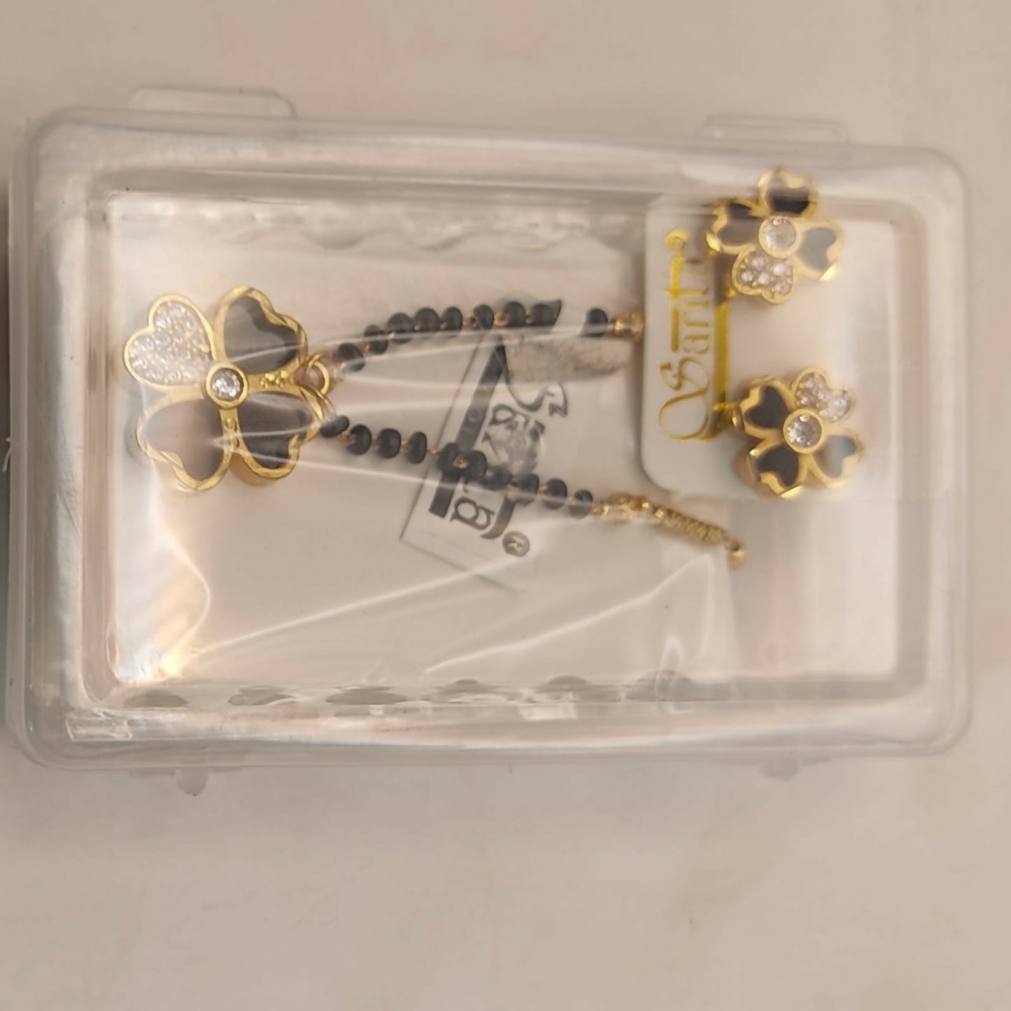 Full set of black clover mangalsutra necklace and matching earrings on display