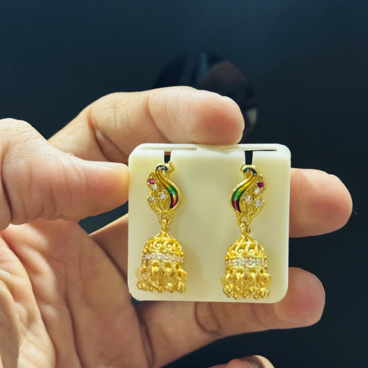 Elegant gold peacock jhumka earrings styled with traditional attire