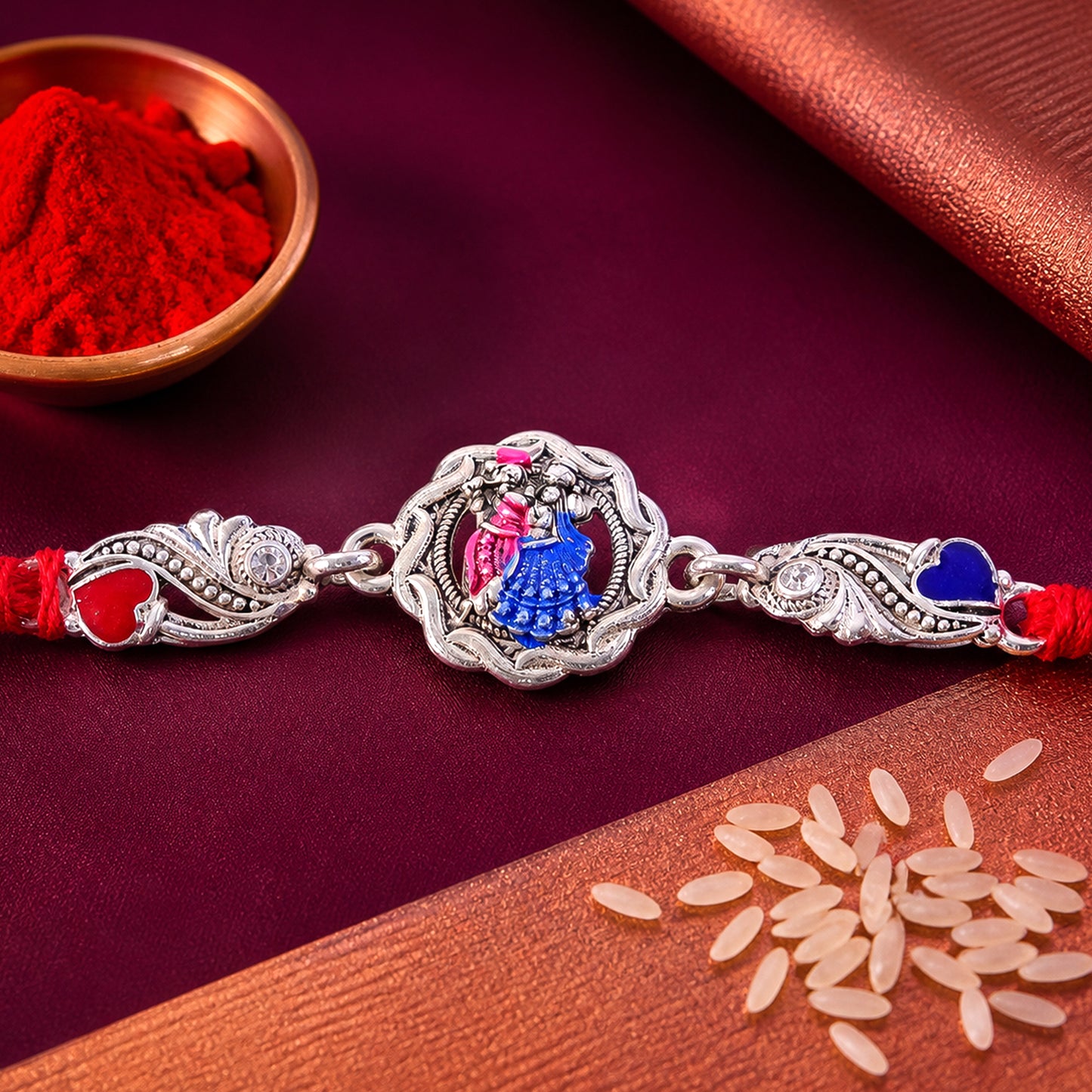 Silver-Toned Radha Krishna Rakhi with Colorful Enamel, Crystal Accents & Designer Red Thread