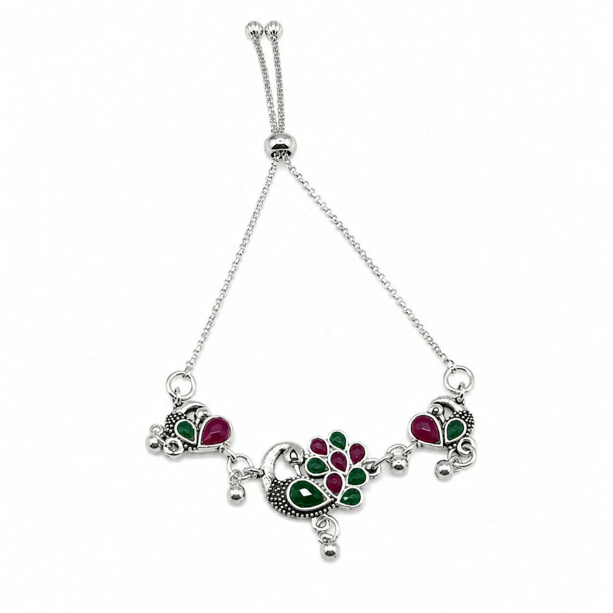 Silver bolo bracelet with ruby and emerald peacock motifs on a white background.