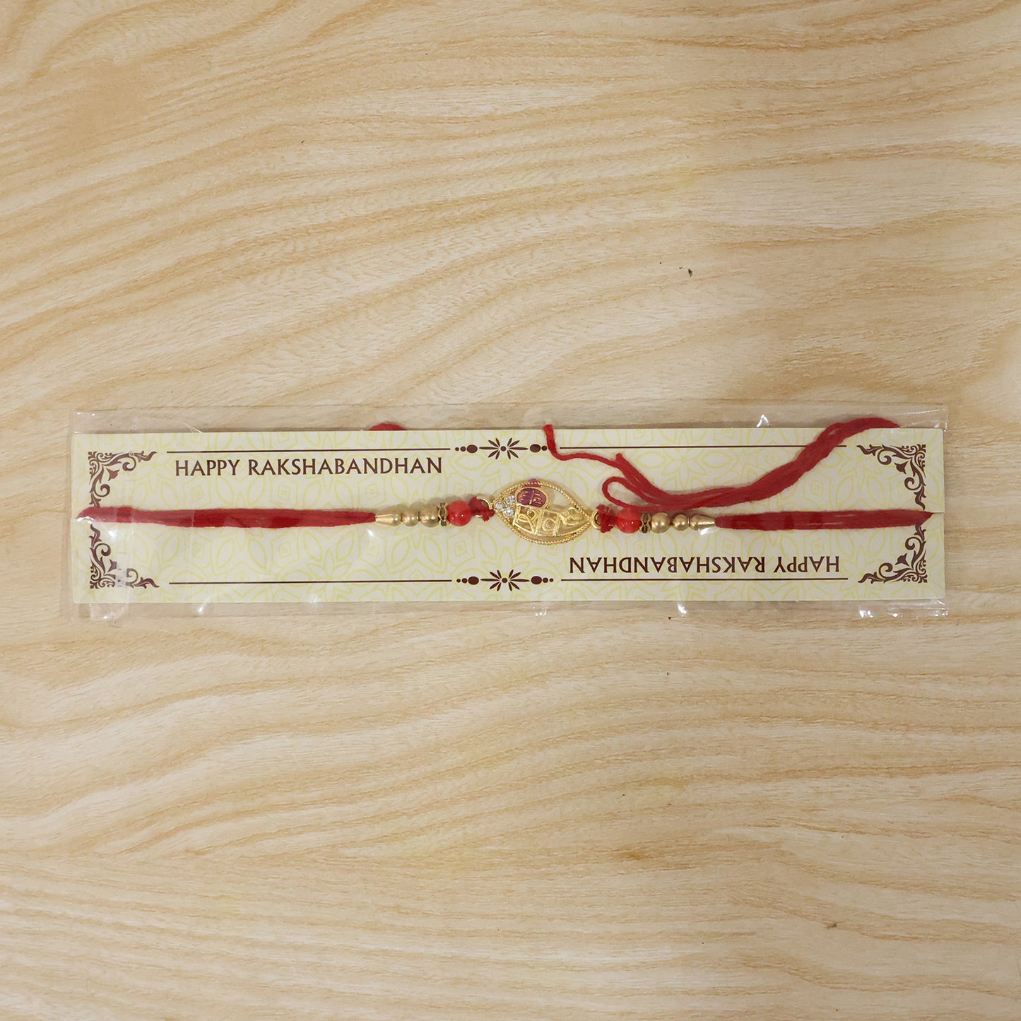 Gold Leaf Shiv Rakhi with Pearl Sides and Red Beads