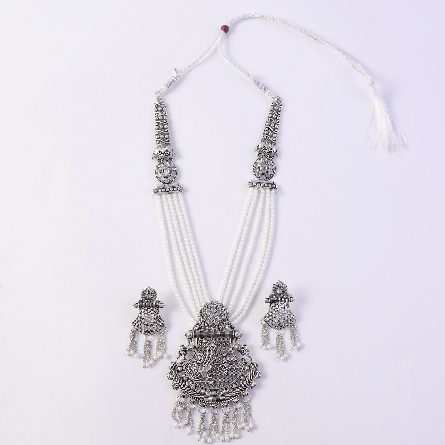 Silver necklace set displayed on ethnic dress