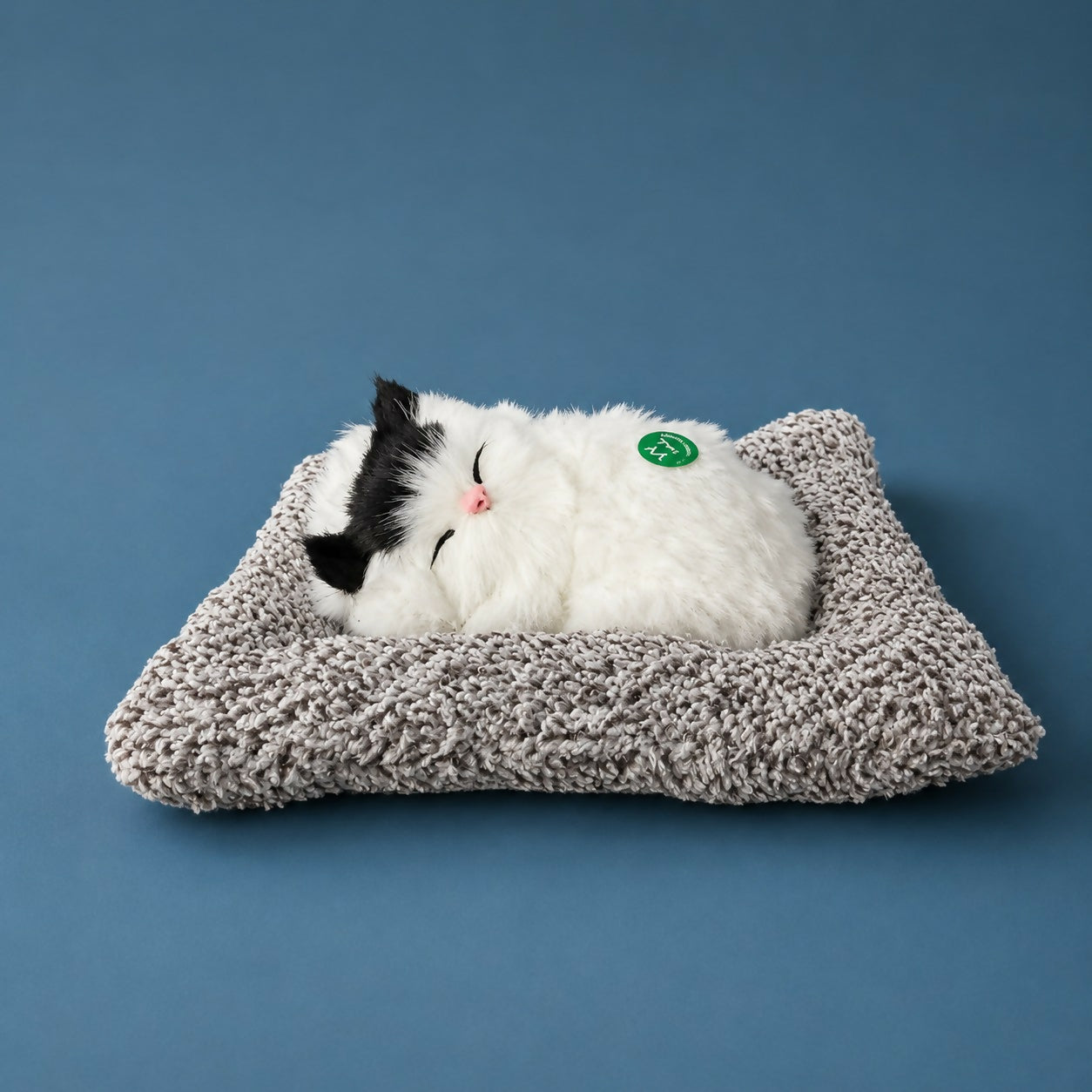 Close-up of sleeping cat plush toy showing detailed fur