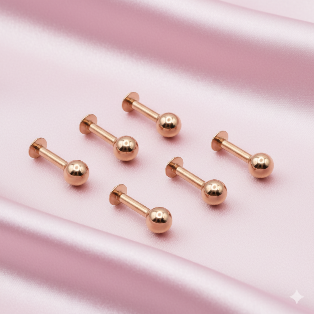 Close-up image showing rose gold labret stud earrings with smooth polished finish.