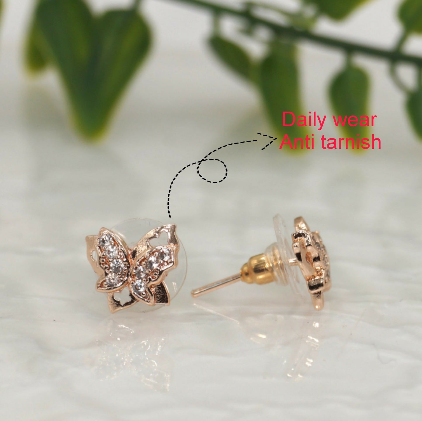 Rose gold plated butterfly stud earrings shown on white background with shimmering pave detail