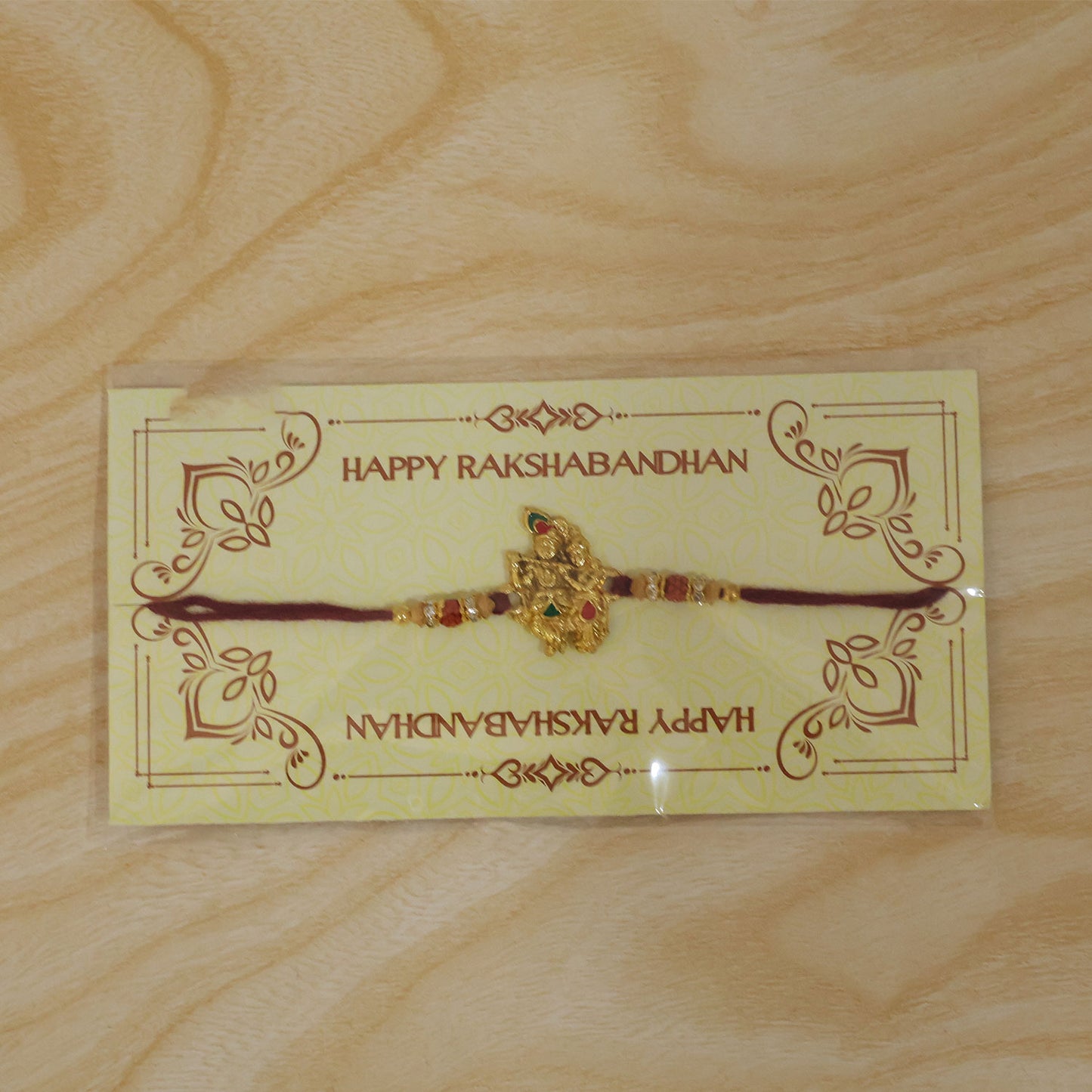 Radha Krishna Golden Devotional Rakhi with Couple Idol Centre and Color Stones