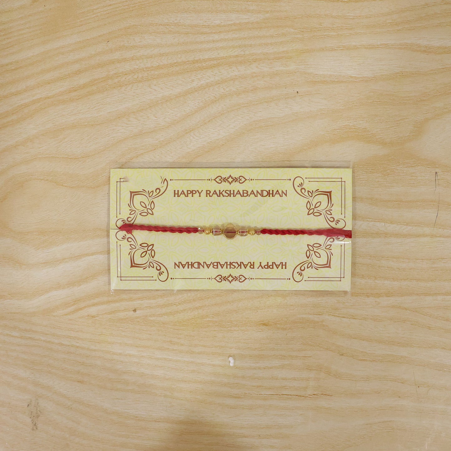 Red Thread Rakhi with Golden and Sparkling Crystal Bead Accents