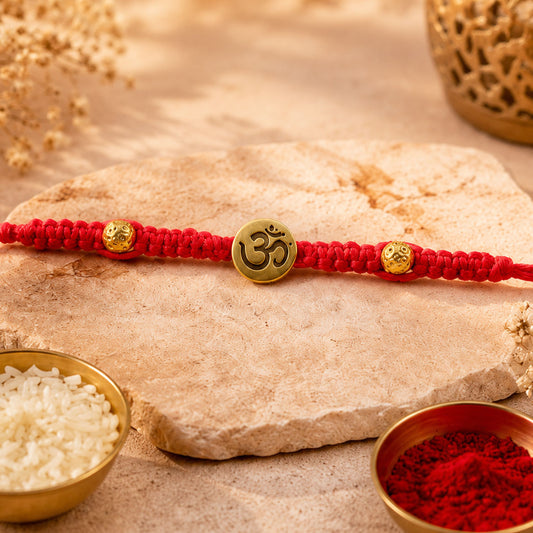 Close up of stone work rakhi with red thread and bead detailing