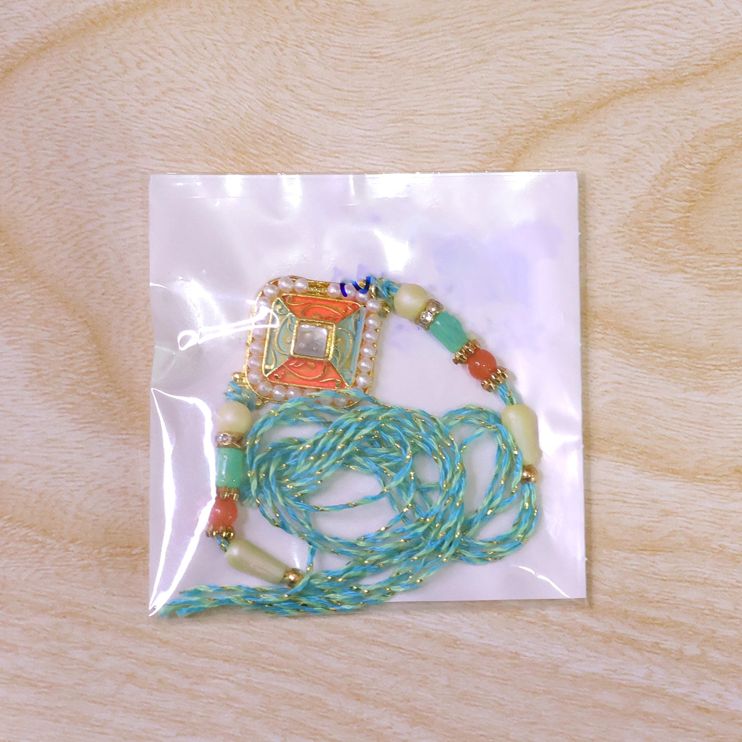 Pearl Bordered Meenakari Pendant Rakhi with Orange and Teal Enamel