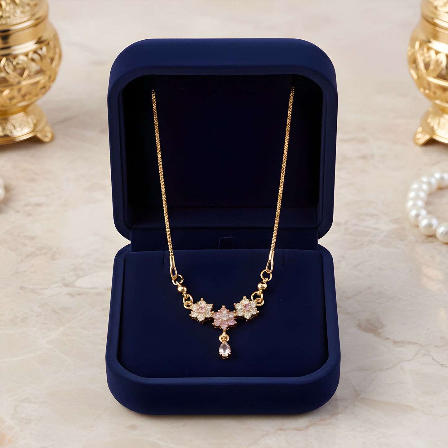 Elegant teardrop pendant hanging from gold finish floral stone necklace