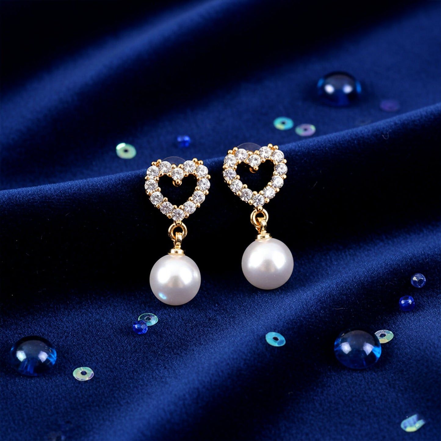 Close-up of heart shaped pearl drop earrings showcasing sparkling cubic zirconia stones