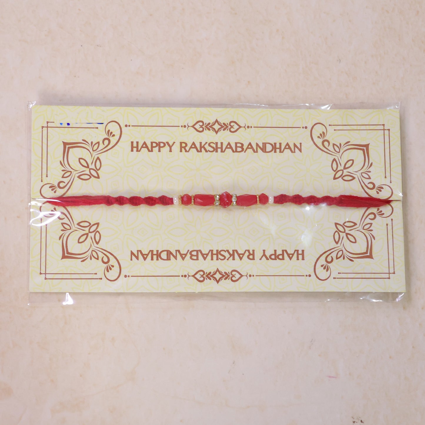 White Thread Rakhi with Smooth Red Oval Bead Accents