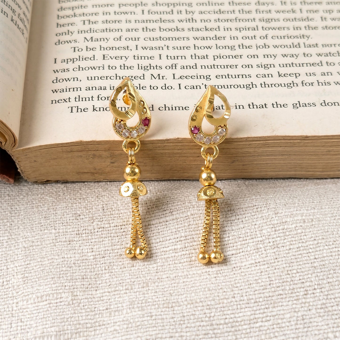 Detailed shot of traditional gold earrings featuring intricate leaf design and beads